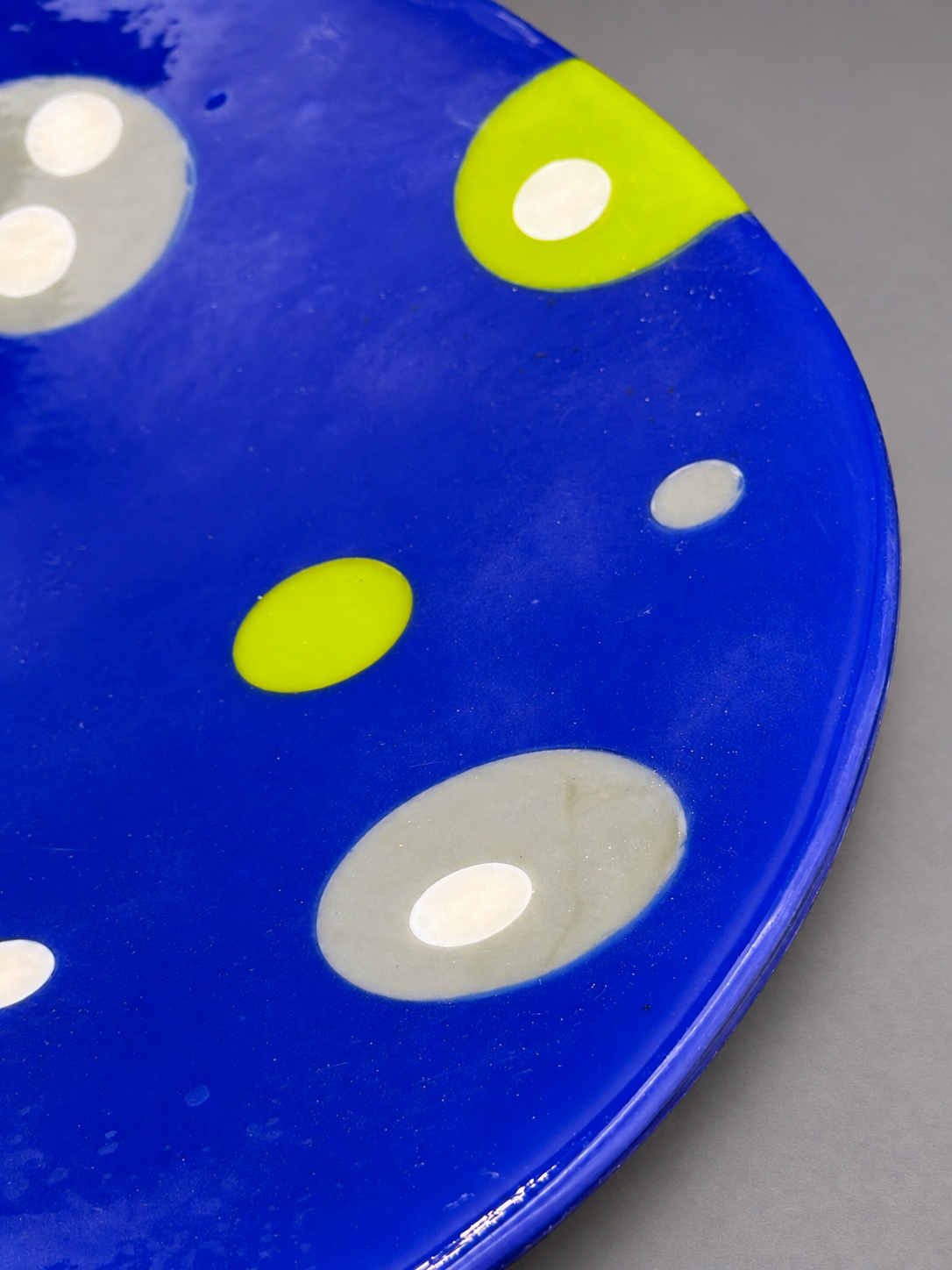 Detail of the chartreuse, gray, and creamy-white bubbles in the cobalt-blue Bubble Dance Platter.